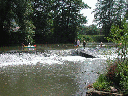 badende Kinder in der Fränkischen Saale bei Westheim an einem Wehr